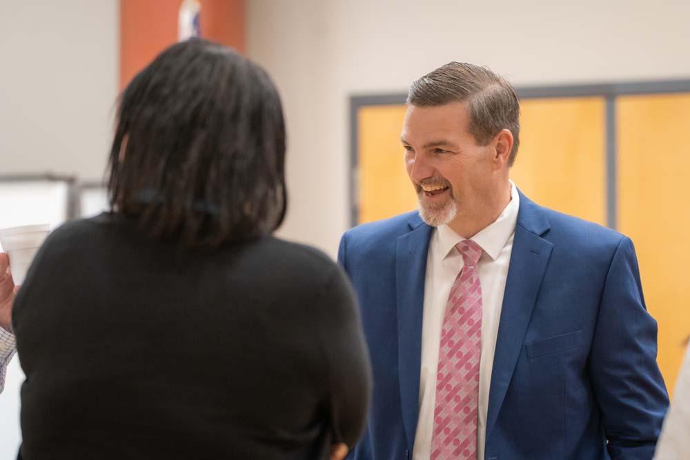 President, Dr. Chris Gray shaking hands